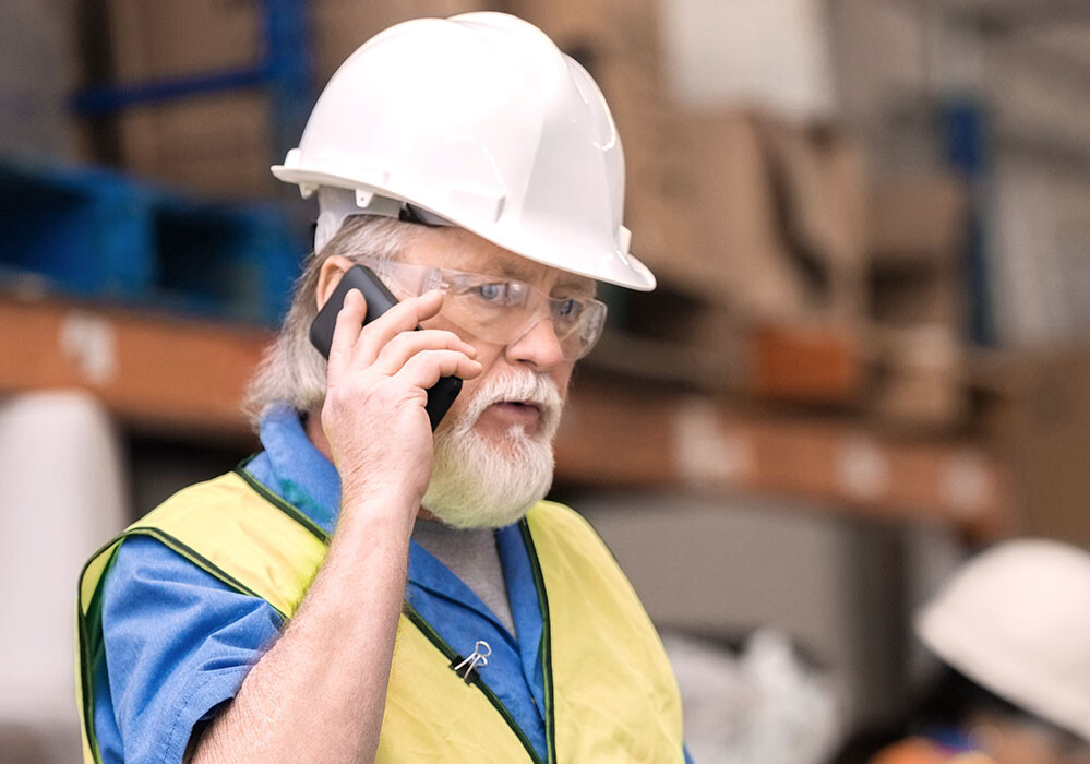 Gain insights in your compressor performance Man in a warehouse on the phone